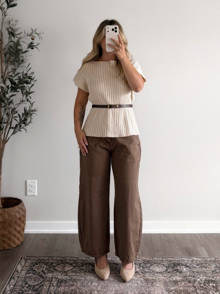 Woman posing in a striped beige top, brown wide-leg trousers, and beige flats.